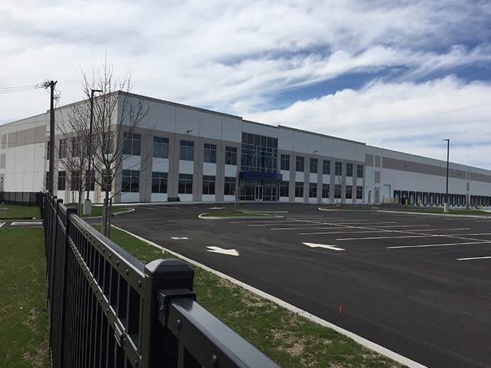 A nondescript warehouse exterior and parking lot.